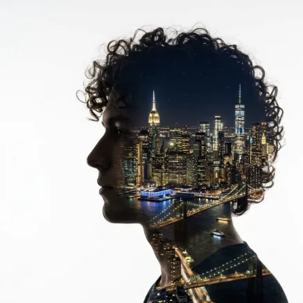 Double exposure art. The silhouette of a young American man with curly hair in profile is filled with the New York City skyline at night. Clean white background, elegant blend.